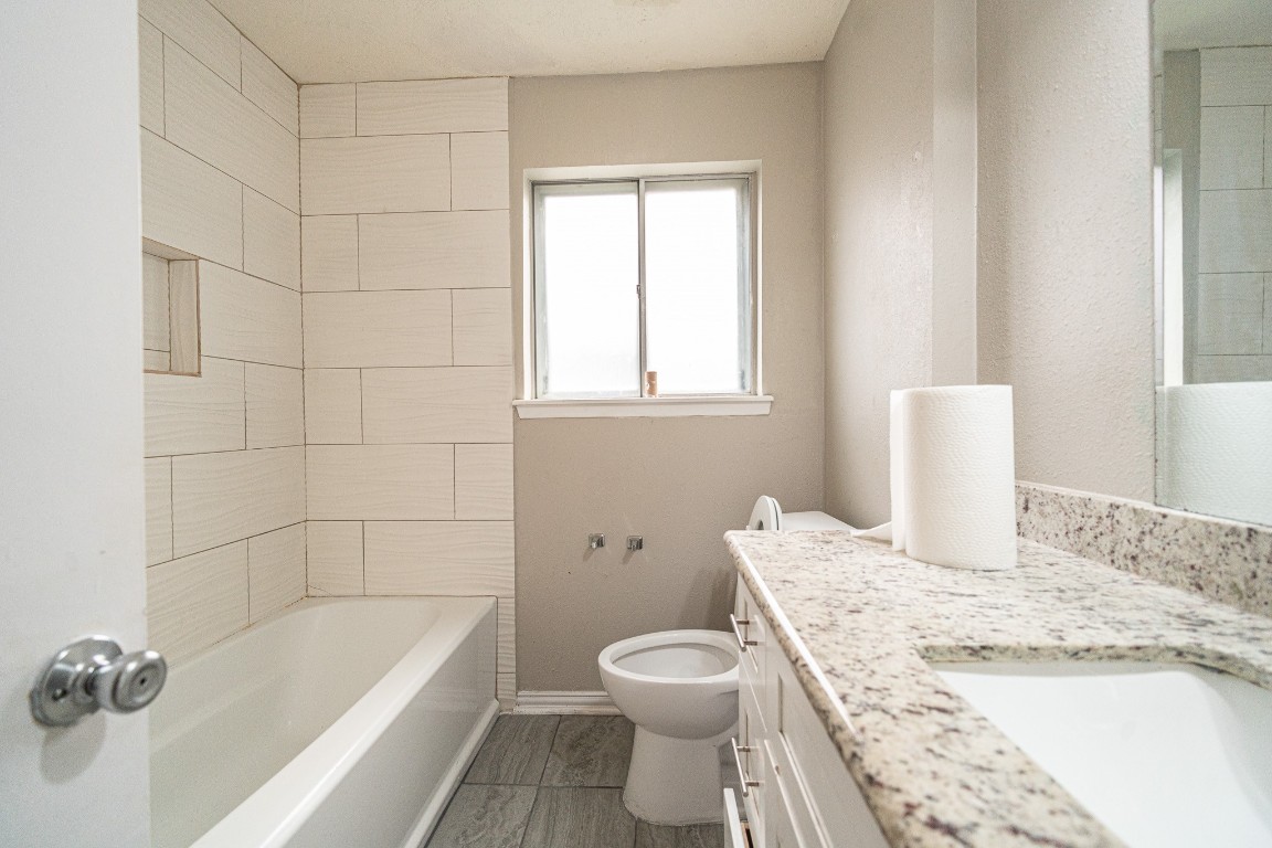 7406 Baneway Drive Houston, TX 77072 - Photo 17 of 22 a bathroom with a granite countertop sink a toilet and bathtub