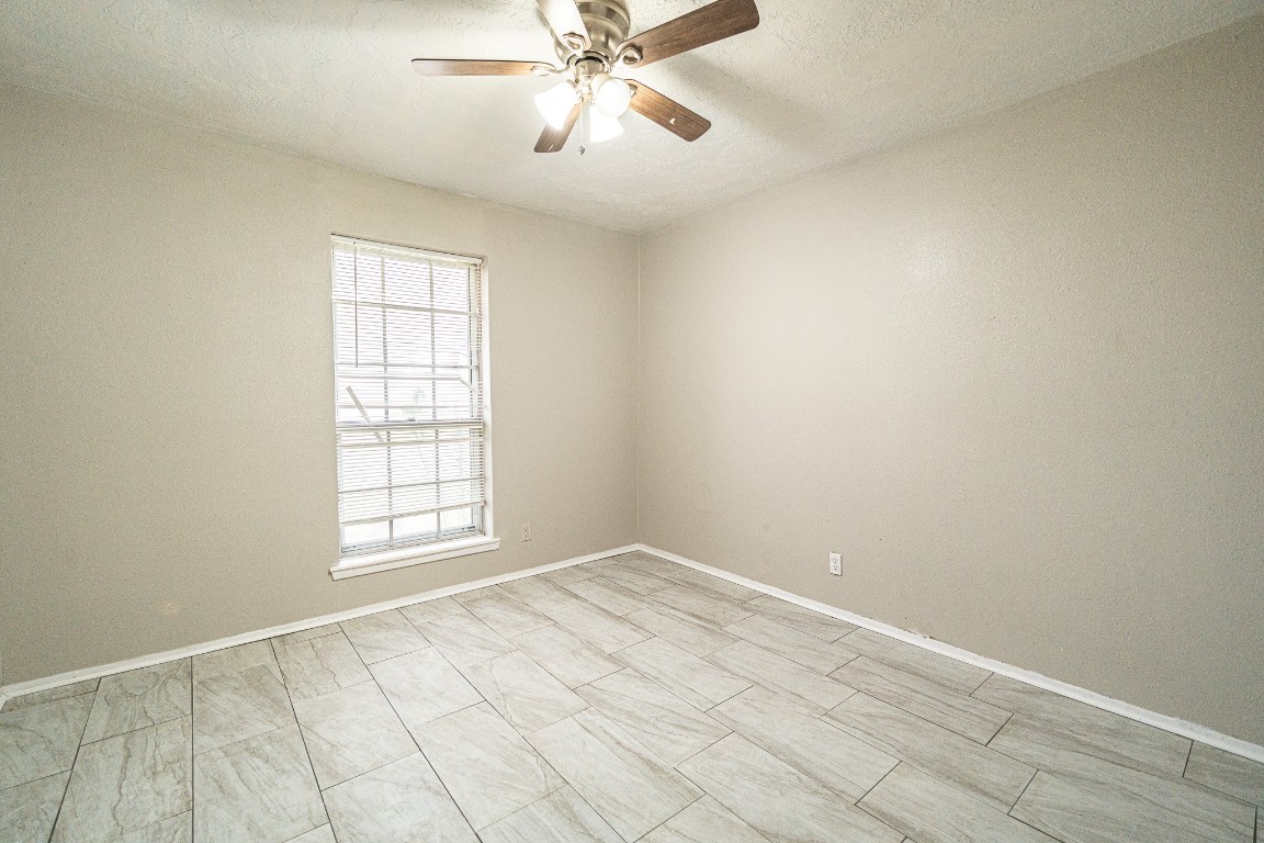 7406 Baneway Drive Houston, TX 77072 - Photo 18 of 22 an empty room with fan and windows