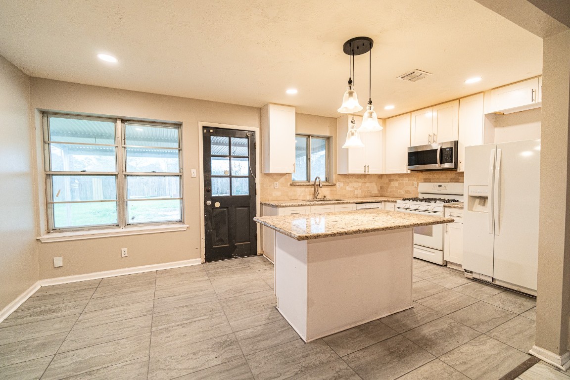 7406 Baneway Drive Houston, TX 77072 - Photo 4 of 22 a kitchen with kitchen island granite countertop a stove and a sink