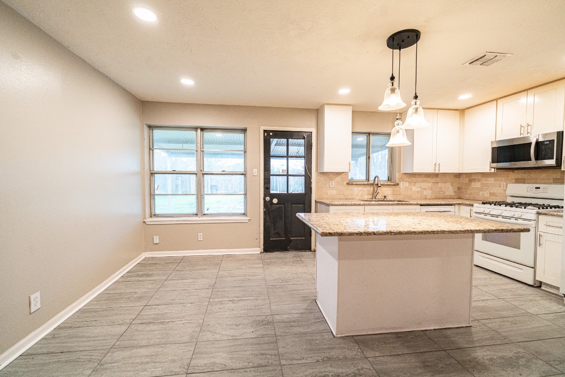7406 Baneway Drive Houston, TX 77072 - Photo 5 of 22 a large kitchen with kitchen island granite countertop a sink a counter top space and stainless steel appliances
