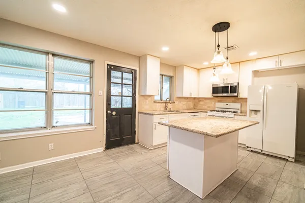 a kitchen with a stove a refrigerator and a sink