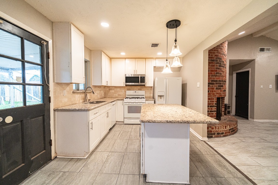 7406 Baneway Drive Houston, TX 77072 - Photo 7 of 22 a large kitchen with granite countertop a sink and dishwasher a stove top oven with granite countertops