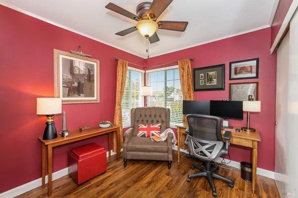 a work room with furniture and paintings on the wall