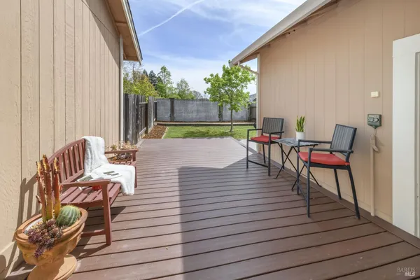 a view of a patio with dining table and chairs with wooden floor
