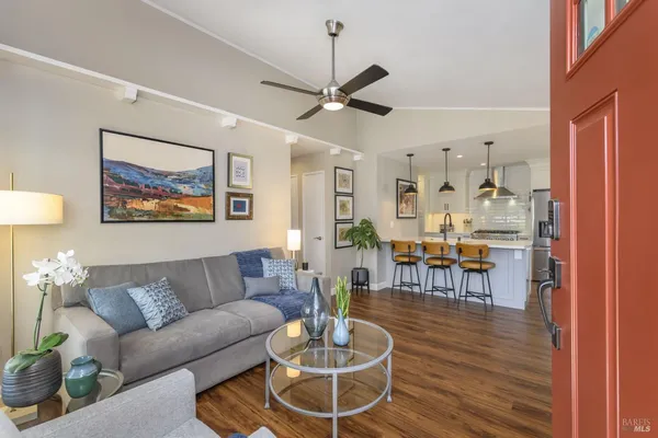 a living room with furniture a dining table and a chandelier