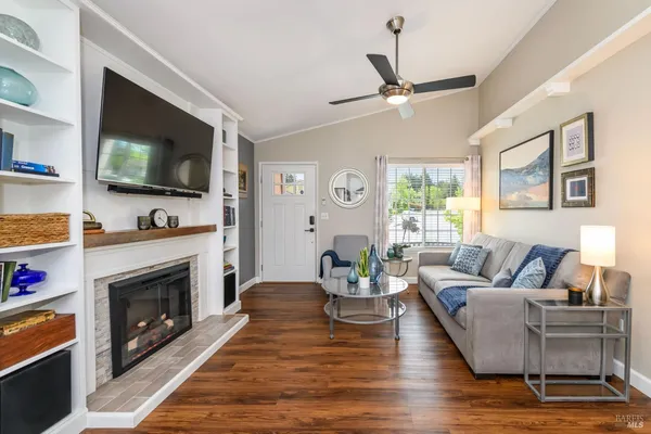 a living room with furniture a flat screen tv and a fireplace