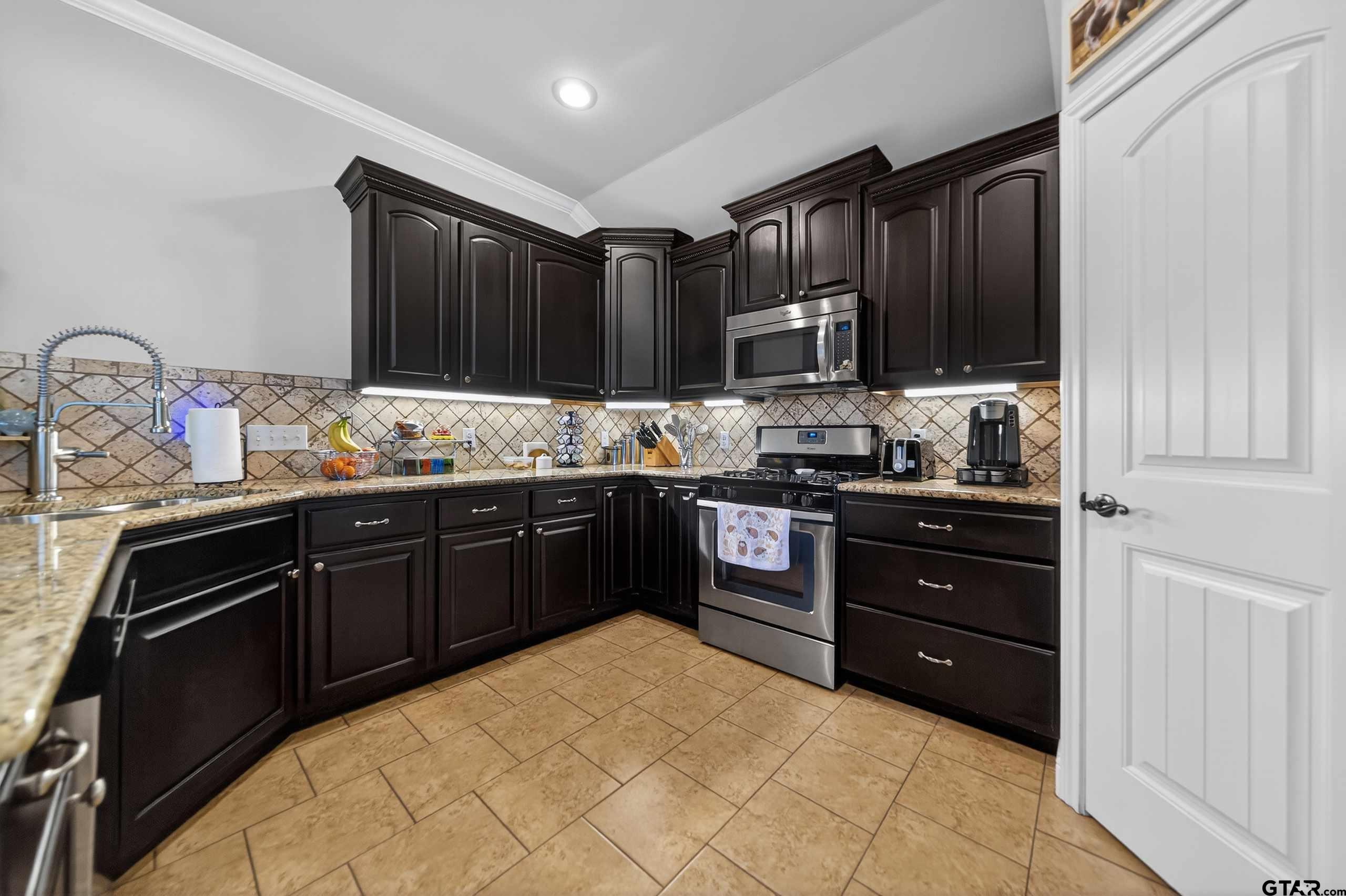 5830 Thompson Place Tyler, TX 75707 - Photo 13 of 35 a kitchen with a sink stove and refrigerator