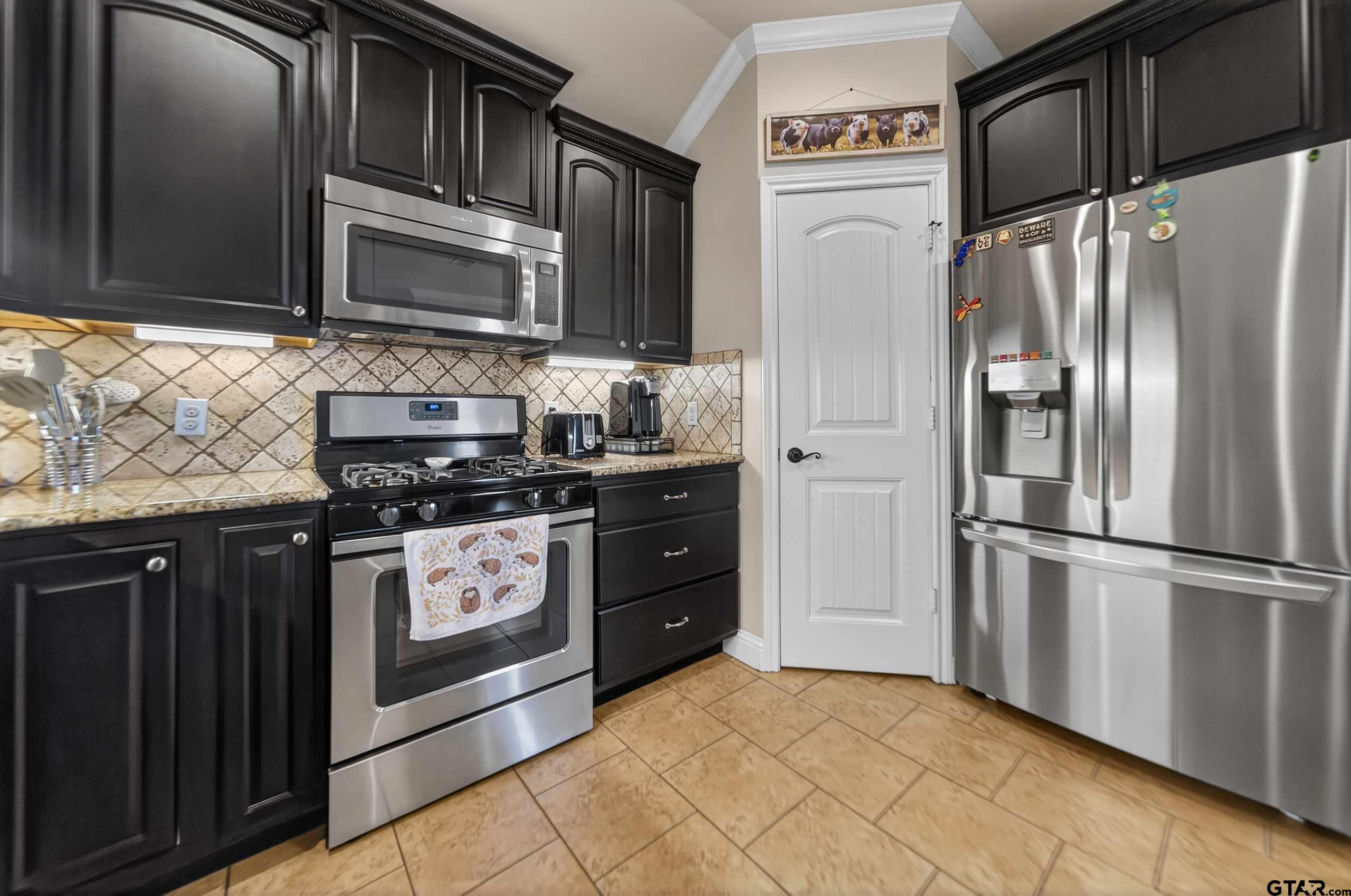 5830 Thompson Place Tyler, TX 75707 - Photo 15 of 35 a kitchen with stainless steel appliances granite countertop a refrigerator stove and microwave
