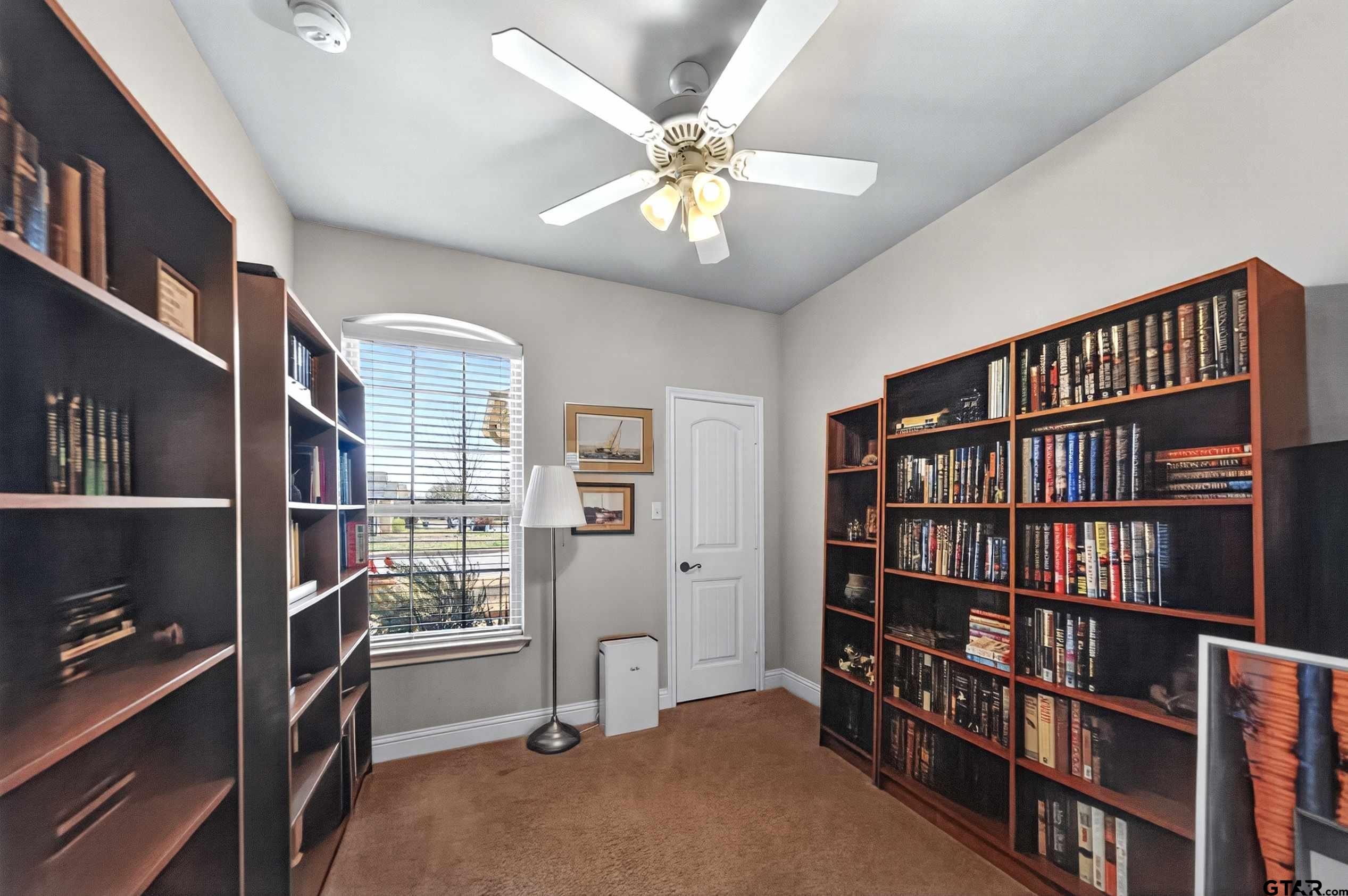 5830 Thompson Place Tyler, TX 75707 - Photo 16 of 35 a view of a livingroom with a bookshelf and a window