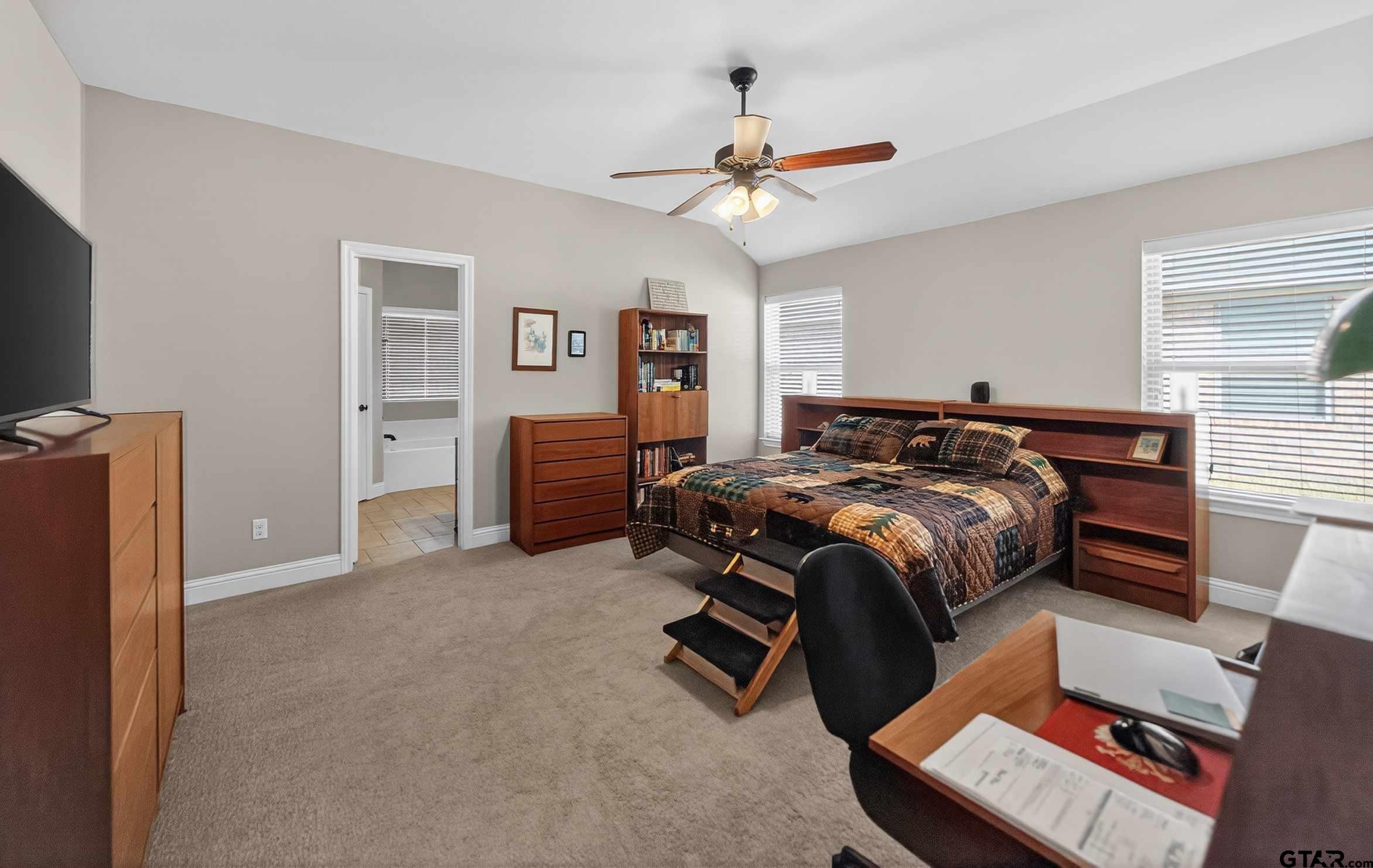 5830 Thompson Place Tyler, TX 75707 - Photo 19 of 35 a bedroom with a bed and a chandelier