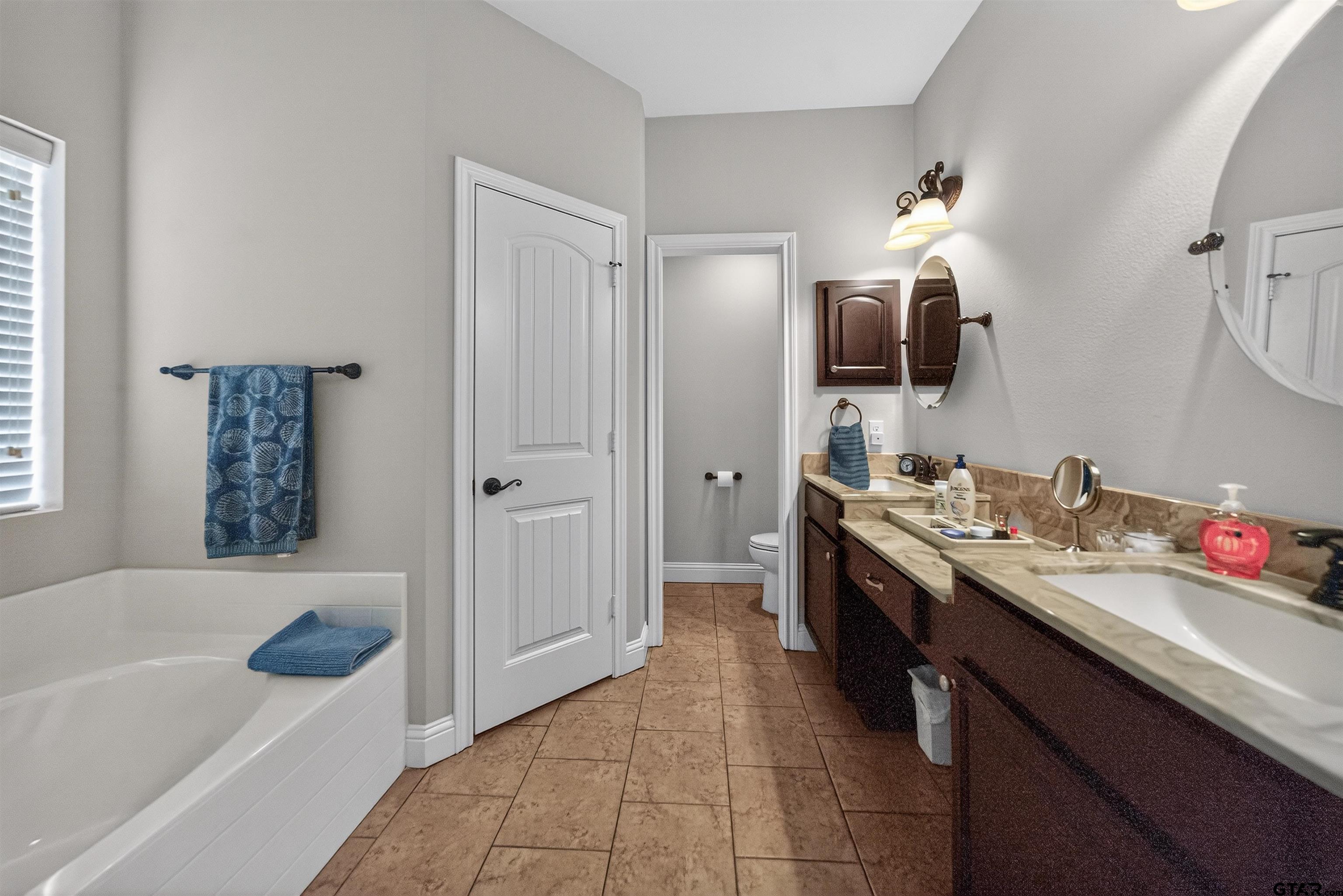 5830 Thompson Place Tyler, TX 75707 - Photo 21 of 35 a bathroom with a tub sink and mirror