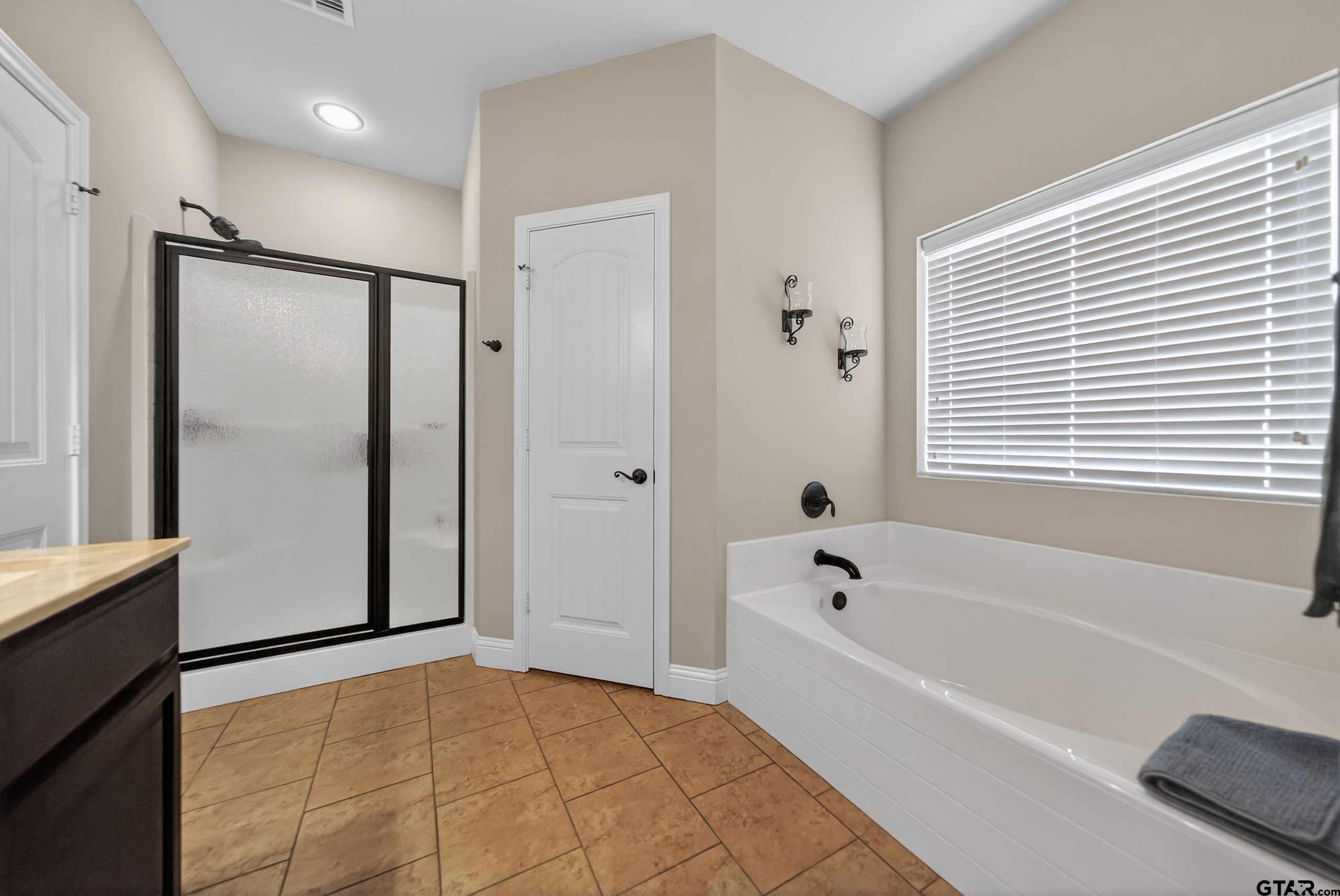 5830 Thompson Place Tyler, TX 75707 - Photo 25 of 35 a bathroom with a bathtub and a shower