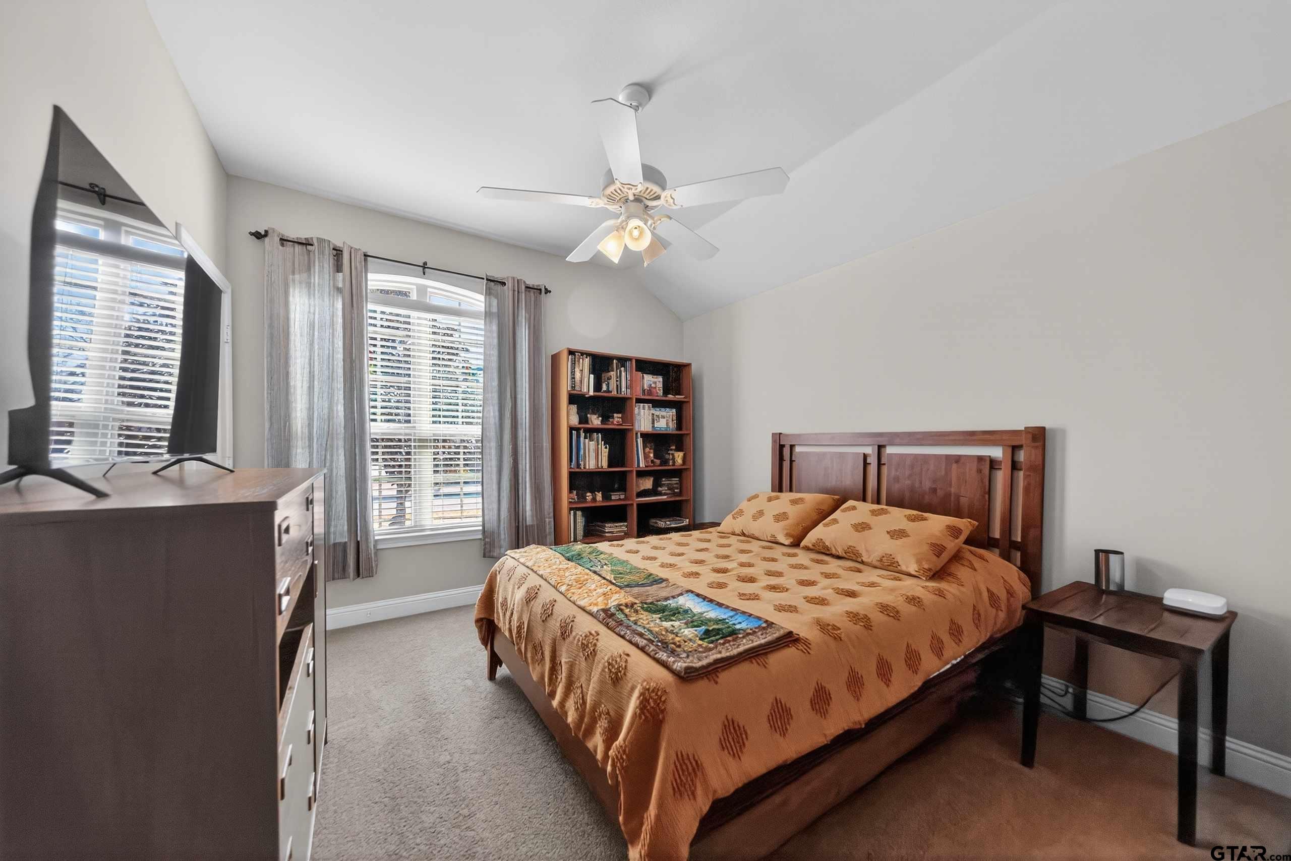 5830 Thompson Place Tyler, TX 75707 - Photo 26 of 35 a bedroom with a large bed and a chandelier