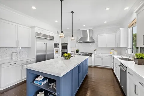 a kitchen with sink a refrigerator and wooden floor