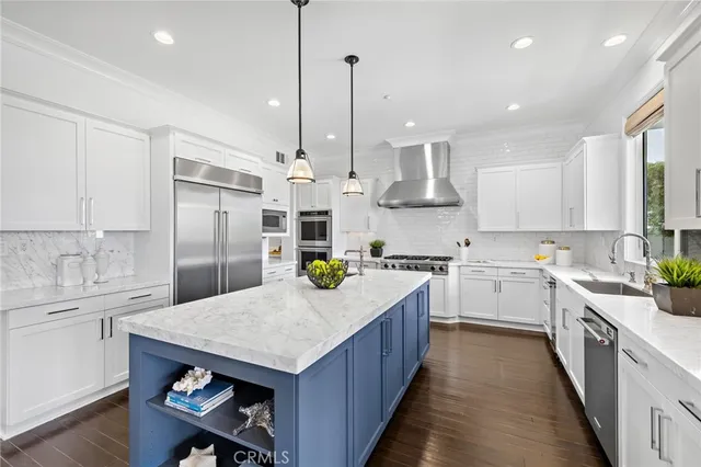 a kitchen with sink a refrigerator and wooden floor