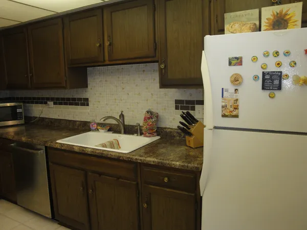 a kitchen with stainless steel appliances granite countertop a sink a refrigerator and a stove