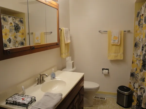 a bathroom with a granite countertop sink a toilet and a mirror