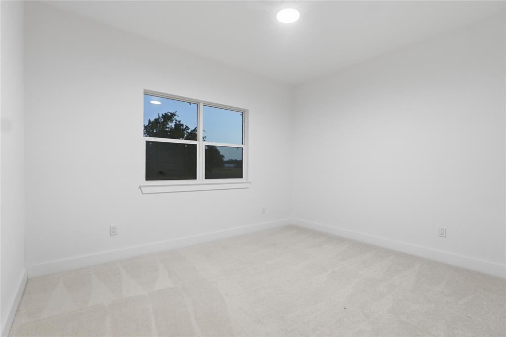 130 Cedar Elm Road Trinidad, TX 75163 - Photo 20 of 27 Bright room featuring a window with white trim, light-toned carpeting, white walls, and a flush-mount ceiling light