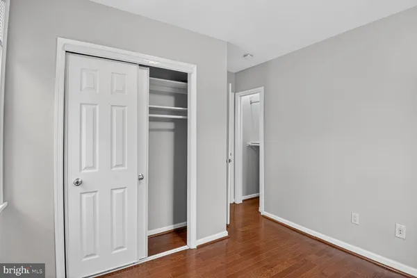 an empty room with wooden floor and closet area