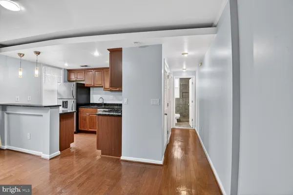 a view of a kitchen with a refrigerator and a stove top oven
