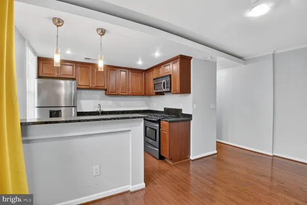 a kitchen with stainless steel appliances granite countertop a sink a stove and a refrigerator