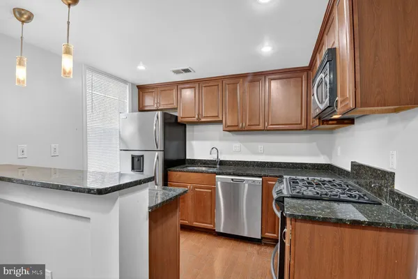 a kitchen with stainless steel appliances granite countertop a sink stove and refrigerator