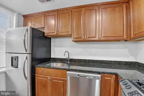 a kitchen with stainless steel appliances granite countertop a refrigerator and a sink