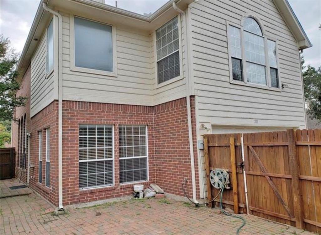 211 Moss Hill Road Irving, TX 75063 - Photo 13 of 14 Rear view of house with brick siding, a gate, and a patio