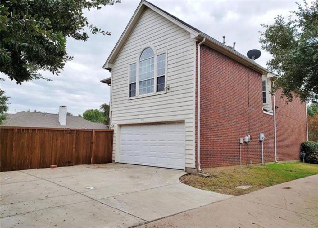 211 Moss Hill Road Irving, TX 75063 - Photo 14 of 14 View of side of property featuring a garage, concrete driveway, and brick siding