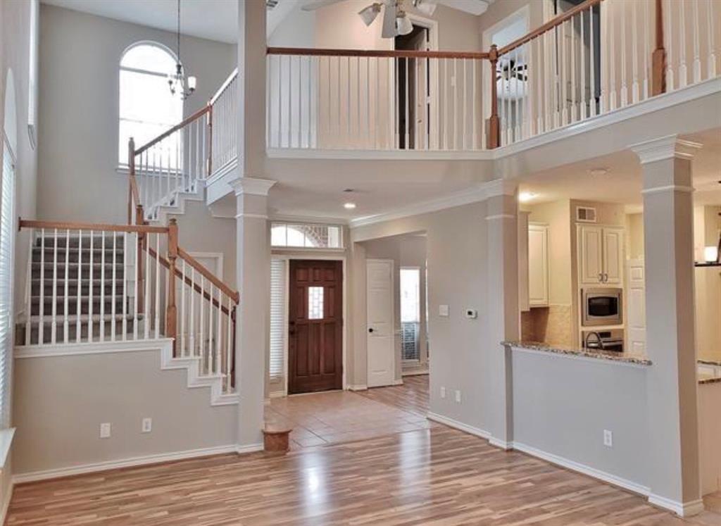 211 Moss Hill Road Irving, TX 75063 - Photo 5 of 14 Entrance foyer featuring a high ceiling, light wood-style floors, ceiling fan, crown molding, and ornate columns