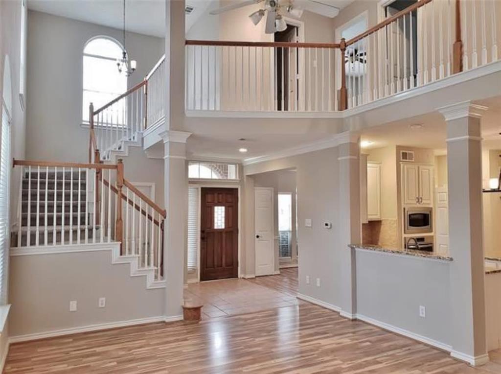 211 Moss Hill Road Irving, TX 75063 - Photo 6 of 14 Entrance foyer featuring a high ceiling, ornate columns, light wood-type flooring, a ceiling fan, and hanging lights