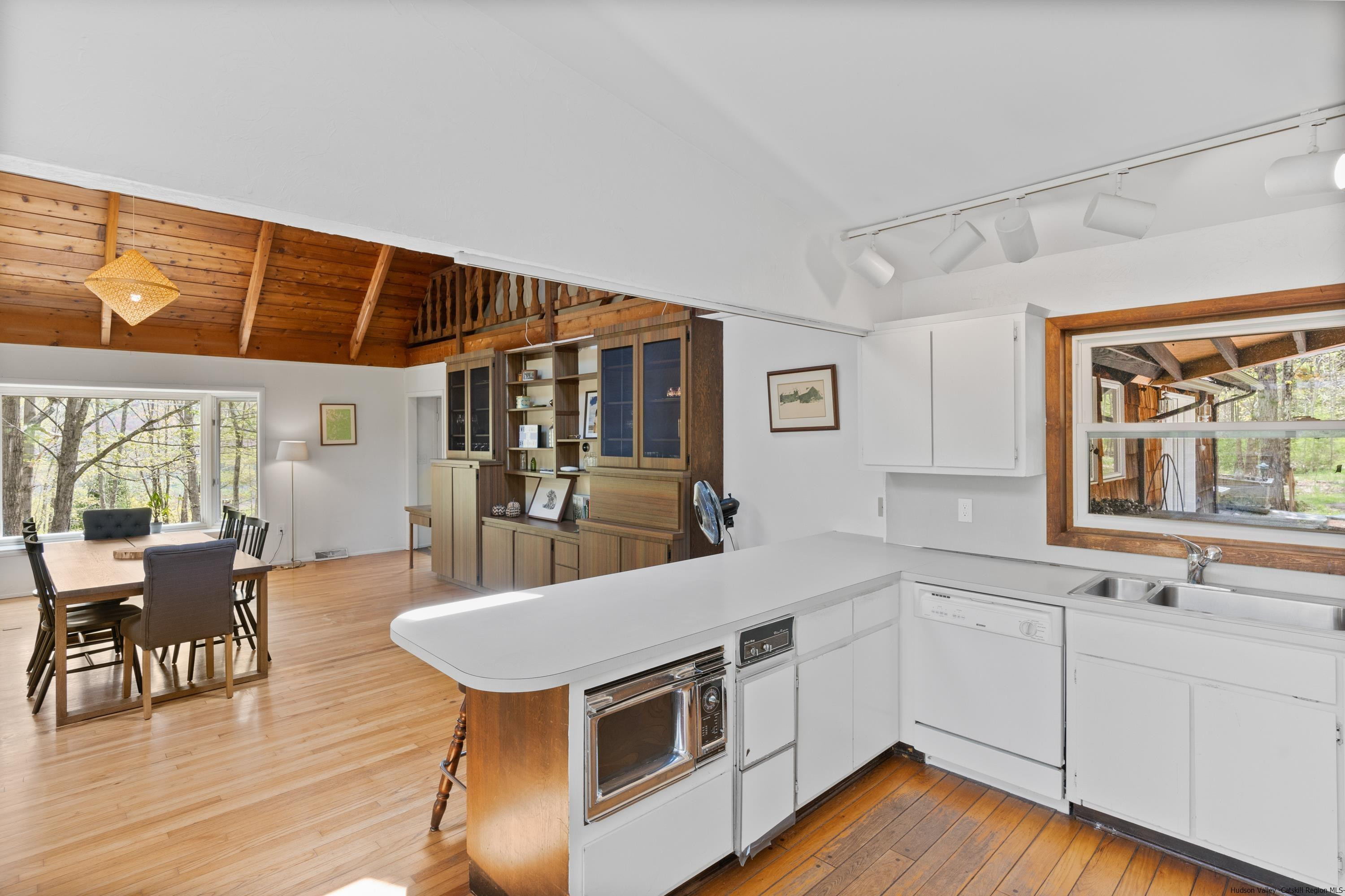 167 Old Towne Road Roxbury, NY 12421 - Photo 12 of 29 a kitchen with stainless steel appliances a stove a sink dishwasher and a dining table with wooden floor