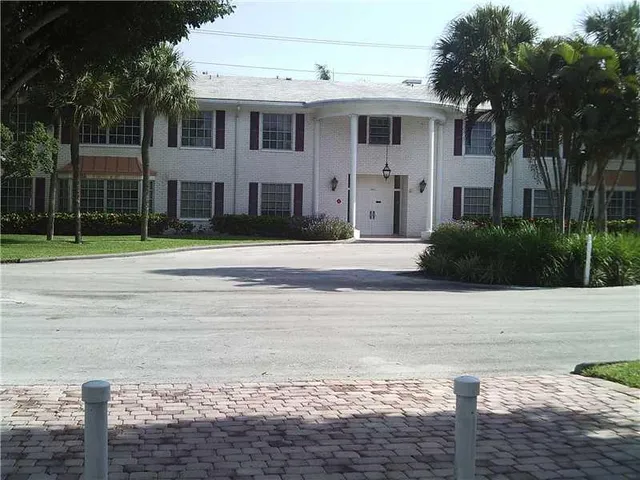 a white house with a yard and plants