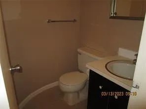 a bathroom with a granite countertop toilet and a sink