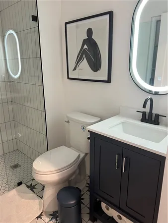 a bathroom with a toilet sink vanity and mirror
