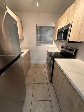 a kitchen with a sink a microwave and cabinets