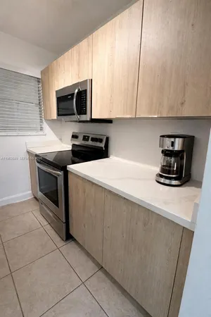 a kitchen with stainless steel appliances a stove a microwave a sink a refrigerator and cabinets