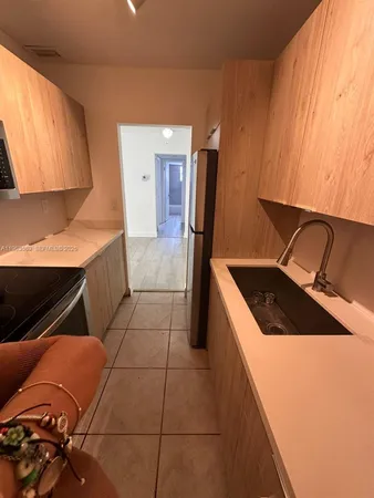 a kitchen with a sink a stove top oven and cabinets