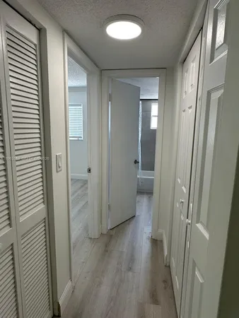 a view of a hallway with wooden floor