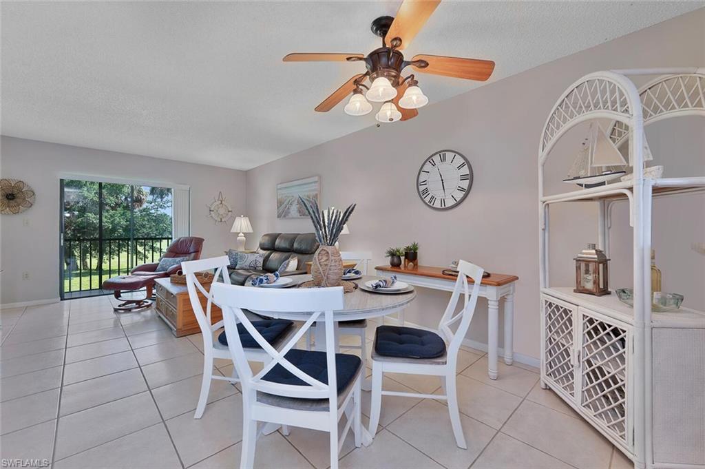 4258 27th Court Southwest, Unit 203 Naples, FL 34116 - Photo 5 of 15 Tiled dining space with ceiling fan and a textured ceiling