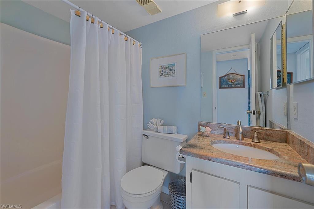 4258 27th Court Southwest, Unit 203 Naples, FL 34116 - Photo 8 of 15 Full bathroom featuring shower / tub combo with curtain, vanity, and toilet