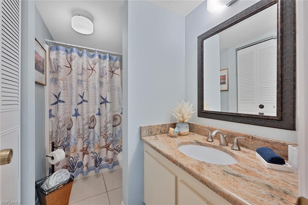 4258 27th Court Southwest, Unit 203 Naples, FL 34116 - Photo 10 of 15 Bathroom with tile patterned floors, curtained shower, vanity, and toilet
