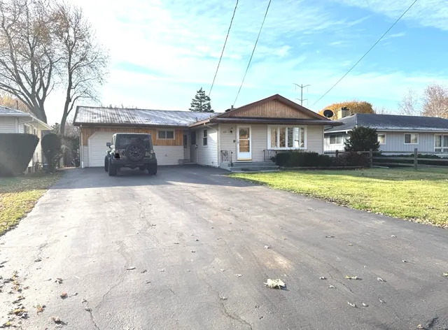 a view of a livingroom with furniture an oven wooden floor and windows