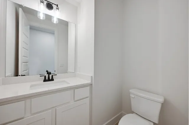 a bathroom with a sink a toilet and mirror