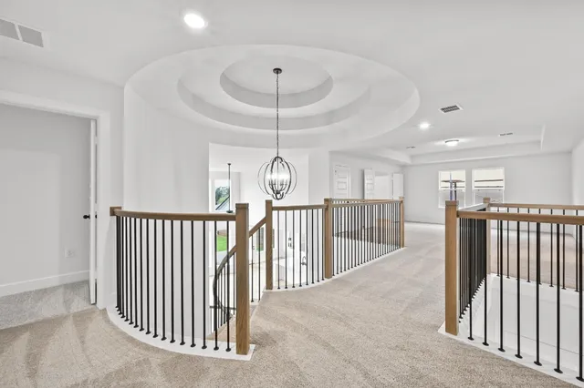 a view of staircase with railing and white walls