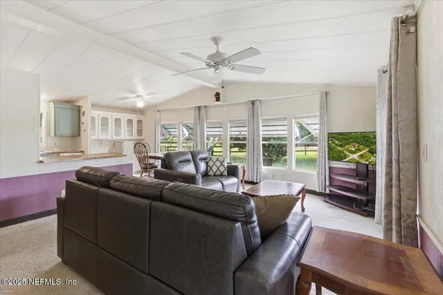 a view of living room with furniture and large windows