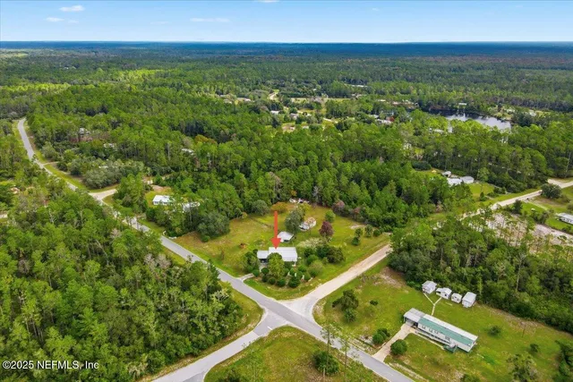 an aerial view of residential houses with outdoor space and trees