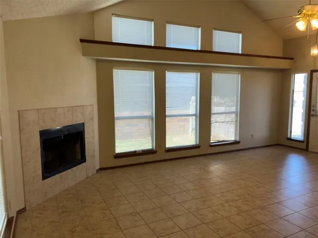 an empty room with wooden floor and fireplace