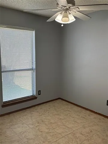 a view of a small space with a ceiling fan and window
