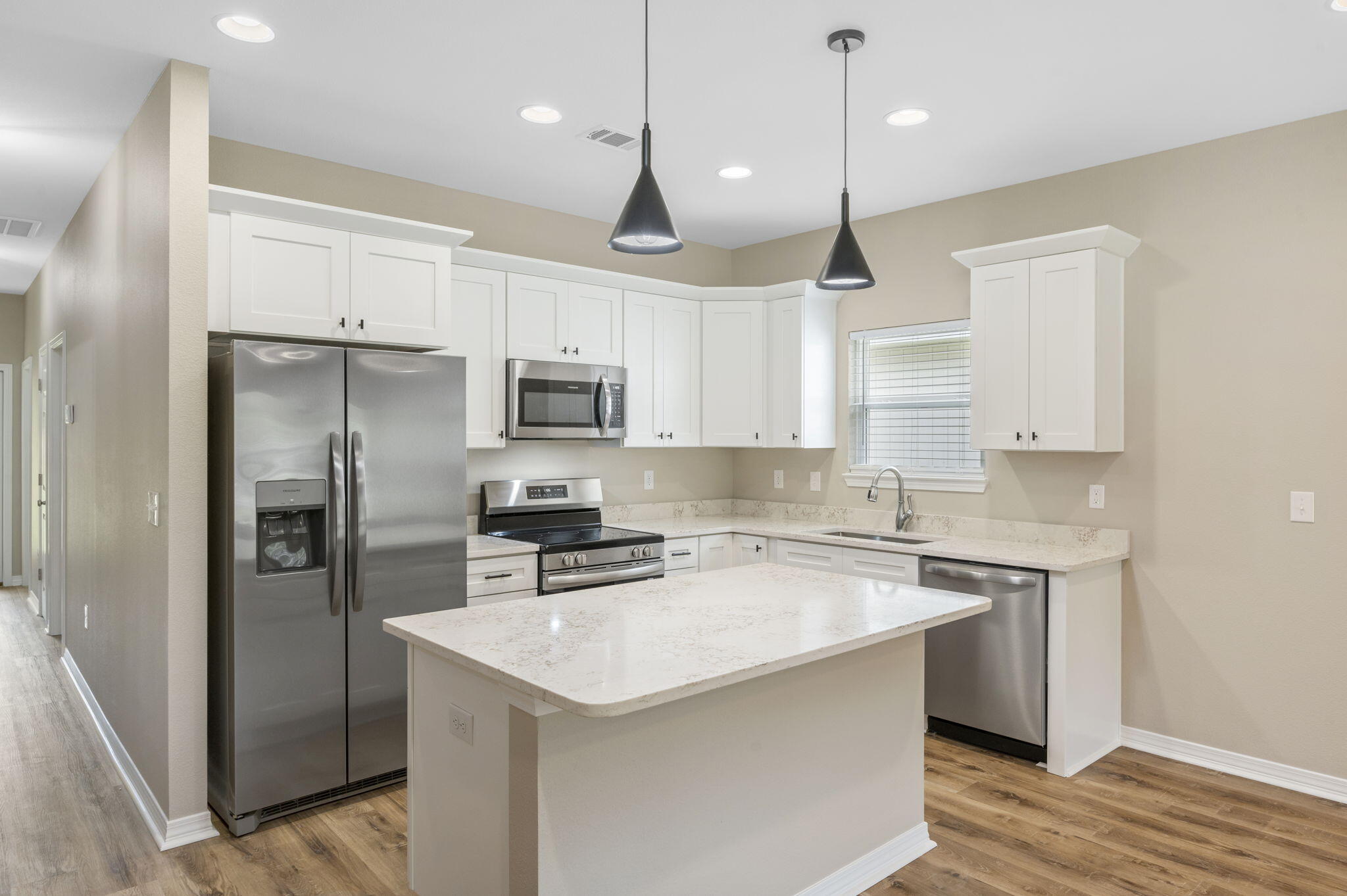 1357 East Chestnut Avenue Crestview, FL 32539 - Photo 17 of 37 a kitchen with a sink a center island a refrigerator and cabinets